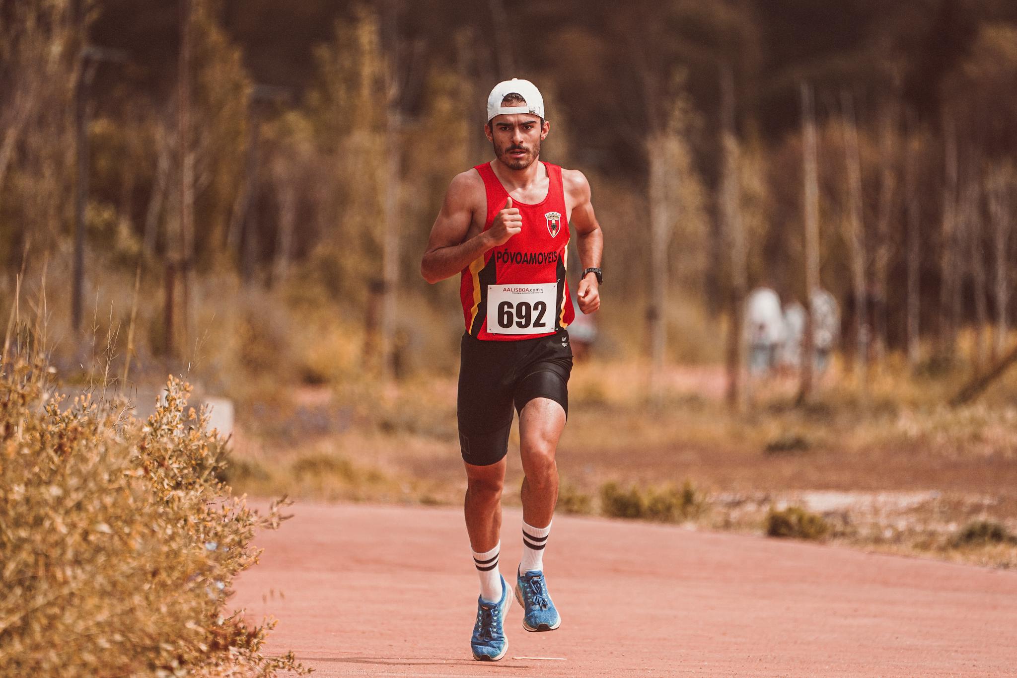 Athletic male runner participating in an outdoor marathon race on a sunny day.