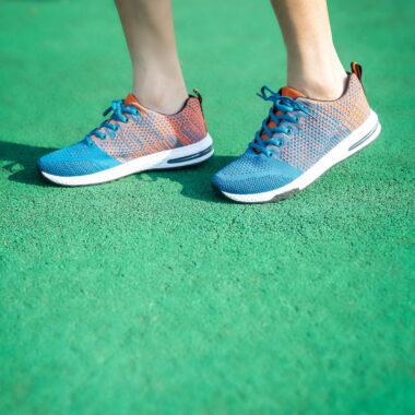 Stylish sneakers on a vibrant green surface, highlighting modern footwear design.